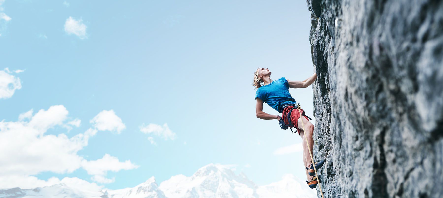 Climber on a mountainside wearing a blue t-shirt